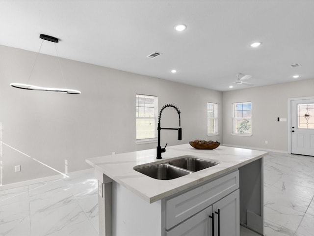 kitchen featuring recessed lighting, visible vents, marble finish floor, and a sink