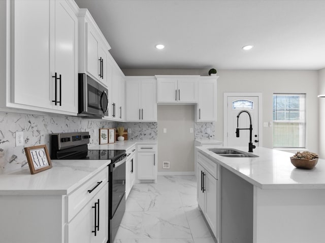 kitchen featuring a sink, decorative backsplash, electric stove, stainless steel microwave, and marble finish floor