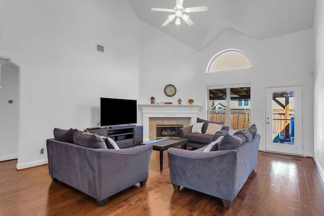 living area featuring hardwood / wood-style floors, baseboards, visible vents, and a tile fireplace