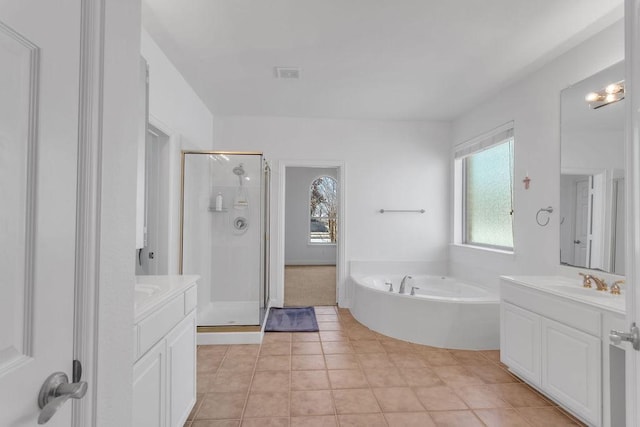 bathroom featuring a sink, two vanities, a stall shower, and a bath