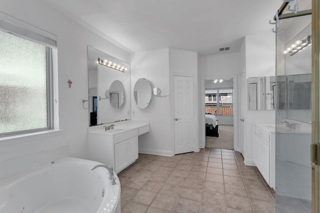 ensuite bathroom with visible vents, two vanities, a whirlpool tub, a sink, and ensuite bathroom