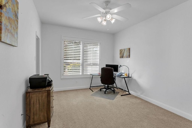 carpeted office space with baseboards and ceiling fan