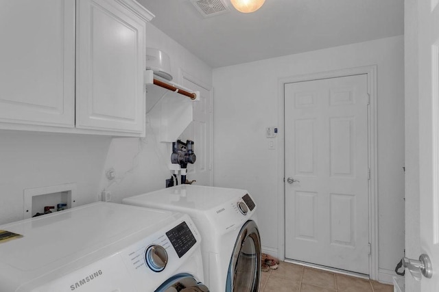 laundry room featuring washer and clothes dryer, visible vents, cabinet space, and light tile patterned flooring