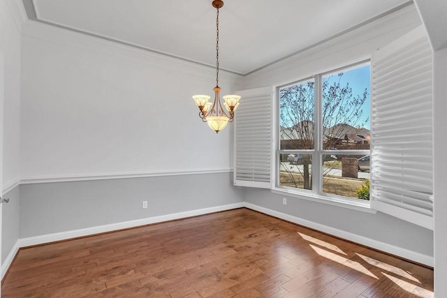 spare room featuring a healthy amount of sunlight, hardwood / wood-style floors, and crown molding