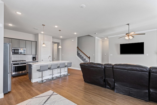 1504 Pleasant Knoll Trl, Aubrey, TX 76227 - living area with visible vents, wood finished floors, recessed lighting, stairway, and baseboards