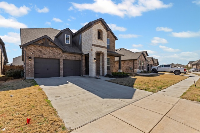 view of front of house with brick siding, a front lawn, roof with shingles, a garage, and driveway