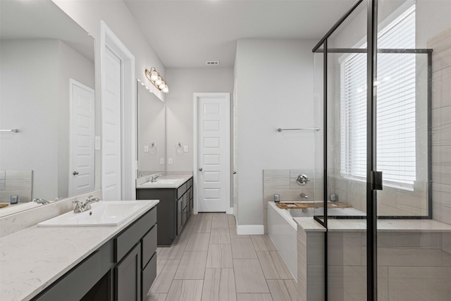 1504 Pleasant Knoll Trl, Aubrey, TX 76227 - bathroom with visible vents, two vanities, a garden tub, and a sink