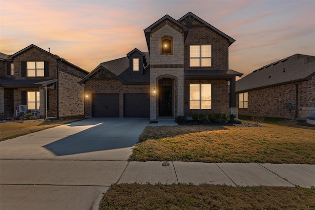 1504 Pleasant Knoll Trl, Aubrey, TX 76227 - view of front of property featuring an attached garage, a yard, concrete driveway, stone siding, and brick siding