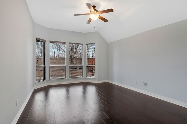 empty room featuring dark wood-type flooring, a ceiling fan, baseboards, and lofted ceiling