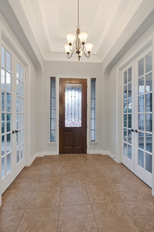 foyer featuring arched walkways, french doors, and crown molding