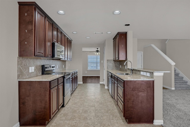 kitchen featuring light stone counters, baseboards, visible vents, a sink, and appliances with stainless steel finishes