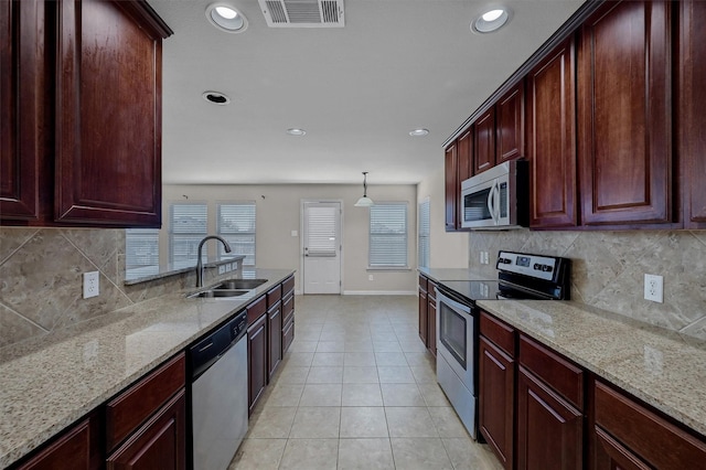 kitchen featuring light tile patterned floors, light stone countertops, visible vents, a sink, and stainless steel appliances