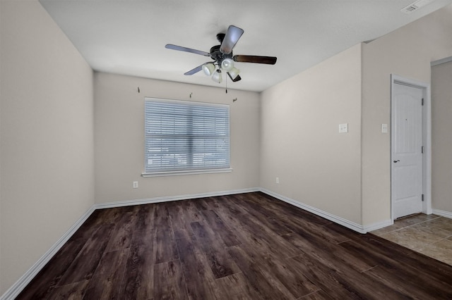 spare room featuring ceiling fan, visible vents, baseboards, and wood finished floors