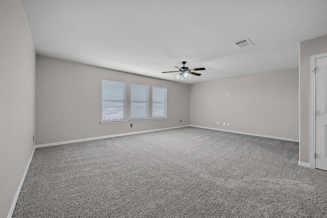 carpeted empty room with visible vents, ceiling fan, and baseboards