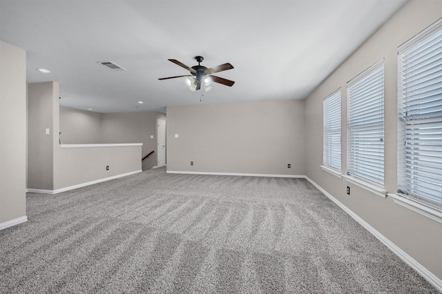 empty room featuring visible vents, baseboards, and carpet flooring