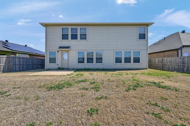 rear view of house with a patio and a fenced backyard