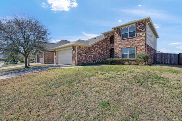 traditional-style house with brick siding, fence, concrete driveway, a front yard, and an attached garage