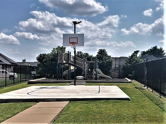 community playground featuring community basketball court, a yard, and fence