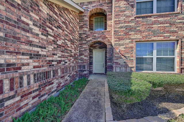 property entrance featuring brick siding