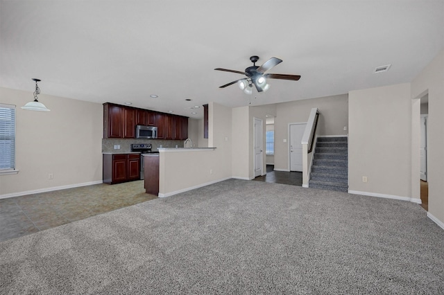 unfurnished living room with visible vents, baseboards, stairs, carpet flooring, and a ceiling fan