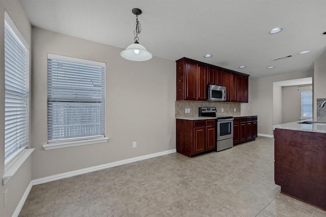 kitchen featuring tasteful backsplash, stainless steel appliances, baseboards, and a sink