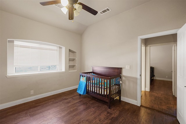 bedroom featuring vaulted ceiling, wood finished floors, visible vents, and baseboards