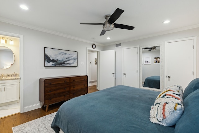 bedroom with visible vents, crown molding, and wood finished floors