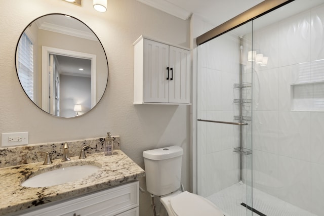 full bathroom featuring vanity, crown molding, toilet, and a stall shower