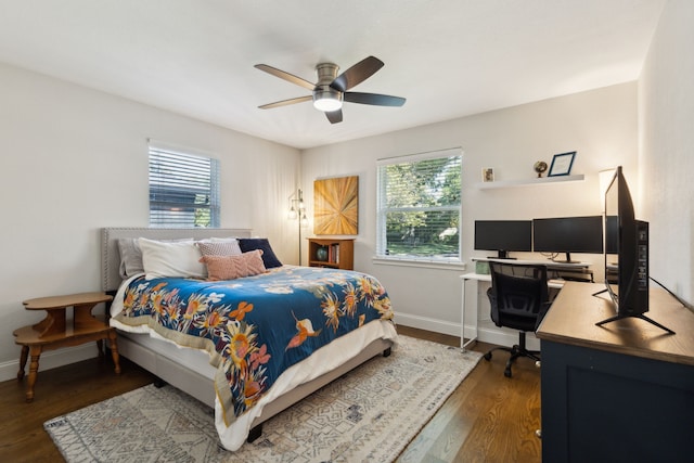 bedroom with ceiling fan, baseboards, multiple windows, and dark wood-style floors