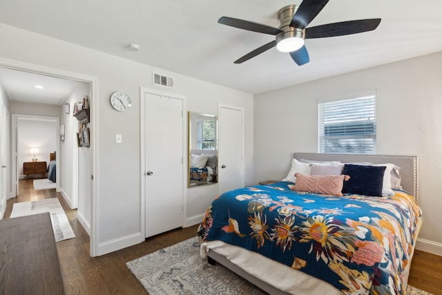 bedroom featuring visible vents, baseboards, wood finished floors, and a ceiling fan