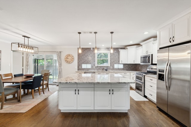 kitchen with visible vents, a kitchen island, dark wood finished floors, appliances with stainless steel finishes, and white cabinets