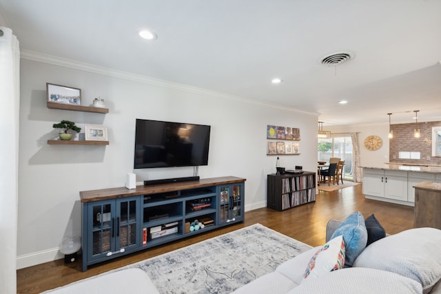 living area with visible vents, baseboards, dark wood-style floors, and ornamental molding