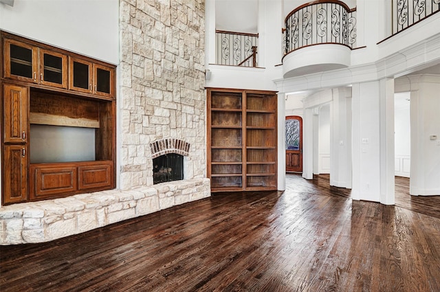 2521 Alexa Ct, Plano, TX 75075 - unfurnished living room featuring a fireplace, wood finished floors, a towering ceiling, and baseboards