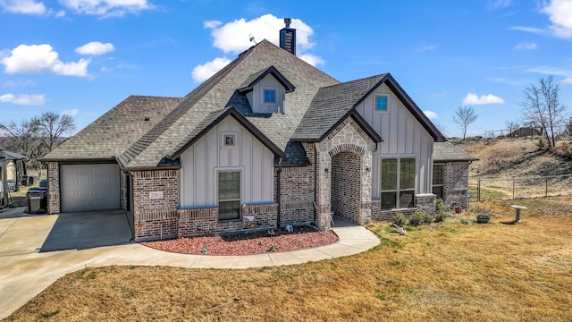 view of front of property featuring a front yard, fence, an attached garage, concrete driveway, and board and batten siding