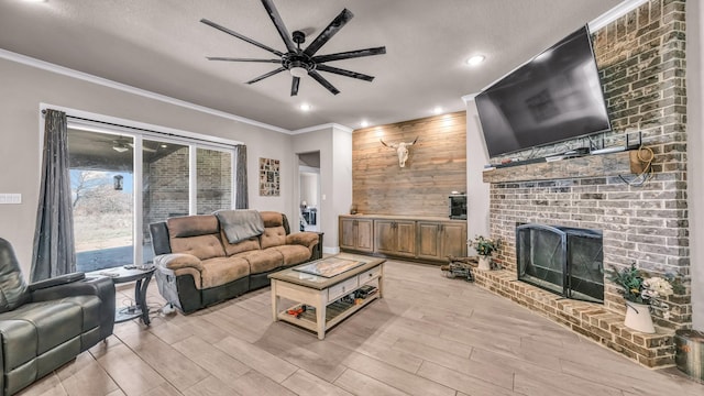 living area featuring crown molding, a brick fireplace, light wood finished floors, and ceiling fan