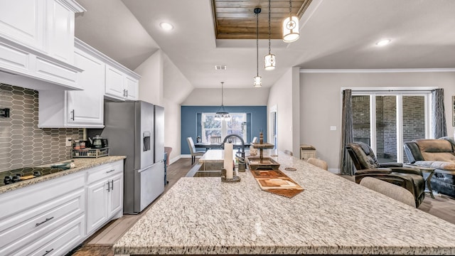 kitchen with backsplash, wood finished floors, white cabinets, stainless steel fridge with ice dispenser, and light stone countertops