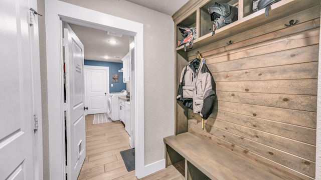 mudroom featuring visible vents, washing machine and dryer, and light wood-type flooring