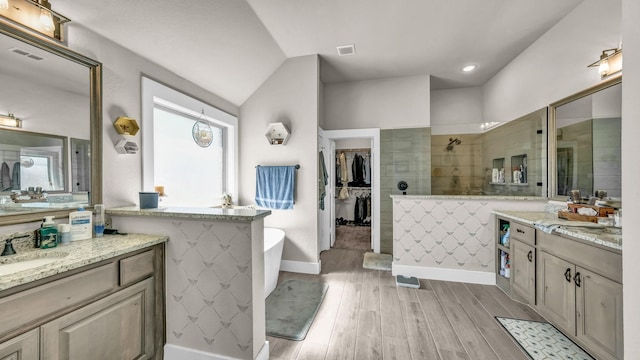 bathroom featuring visible vents, a sink, wood finished floors, a soaking tub, and walk in shower