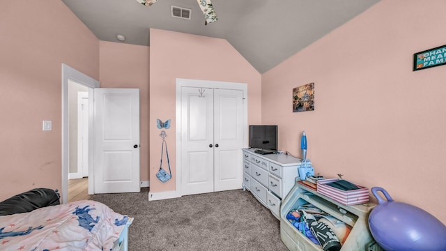 carpeted bedroom featuring visible vents, a closet, and vaulted ceiling