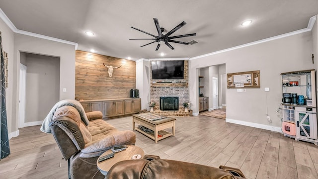 living area with baseboards, light wood-style floors, a brick fireplace, and crown molding