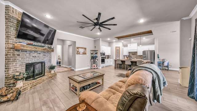 living area featuring visible vents, a brick fireplace, light wood-type flooring, and ornamental molding