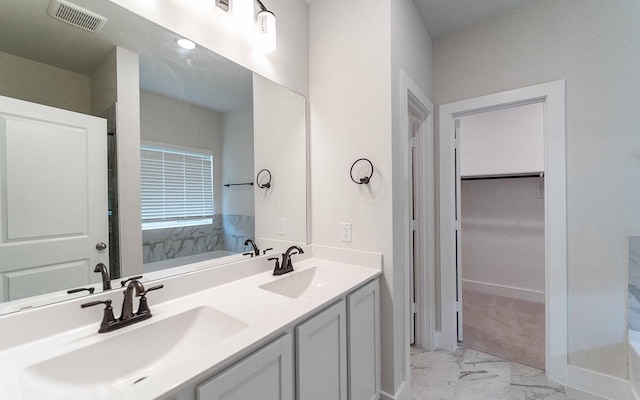 full bath with a spacious closet, visible vents, marble finish floor, and a sink