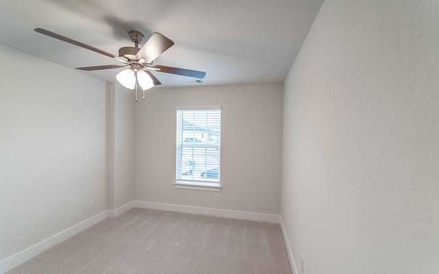 empty room featuring ceiling fan, baseboards, visible vents, and light carpet