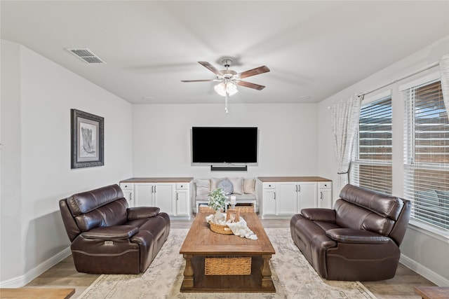 living area with visible vents, baseboards, a healthy amount of sunlight, and light wood-style flooring