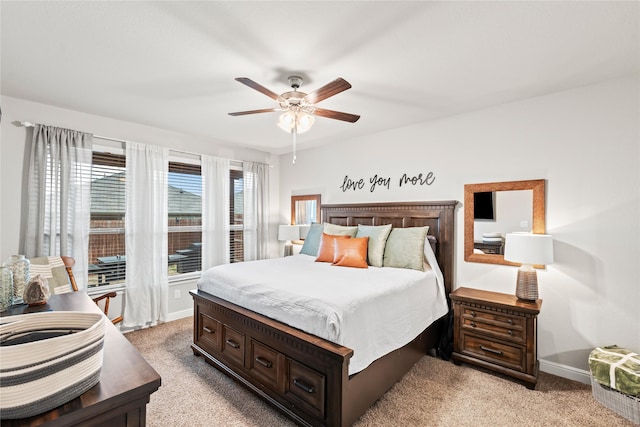 bedroom with light colored carpet, baseboards, and ceiling fan