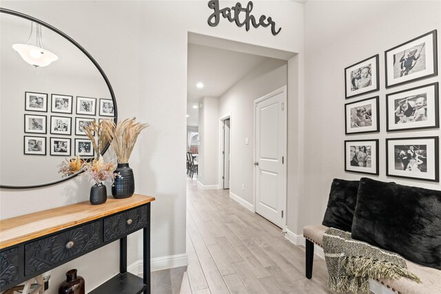 corridor featuring wood finished floors and baseboards