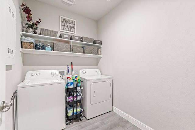 laundry area featuring baseboards, light wood-style flooring, laundry area, and washing machine and clothes dryer