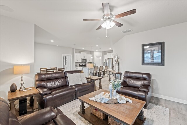 living area featuring a ceiling fan, baseboards, visible vents, recessed lighting, and light wood-type flooring