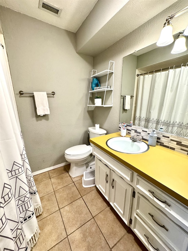 bathroom featuring visible vents, baseboards, toilet, tile patterned floors, and vanity