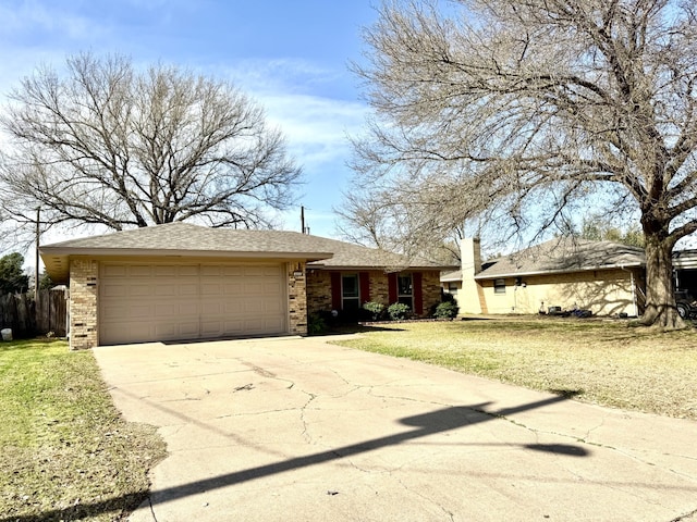 ranch-style home featuring a front yard, fence, concrete driveway, a garage, and brick siding